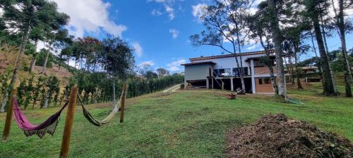a house on a hill with hammocks in the yard at Recanto na Mantiqueira in Gonçalves