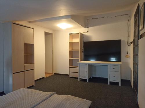 グダニスクにあるSeaside Amber Apartmentの大型テレビと机のある寝室