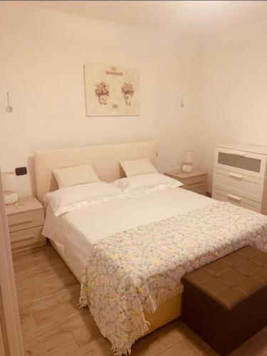 a bedroom with a large white bed and two night stands at La Casetta di Nico in Beverone