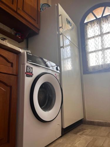 a washing machine in a kitchen next to a refrigerator at Karitsa's Holiday Home in Karítsa