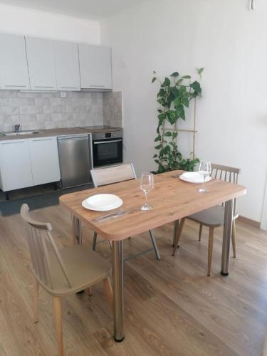 a wooden table with two chairs and a kitchen at Sun Meets Sea in Athanion