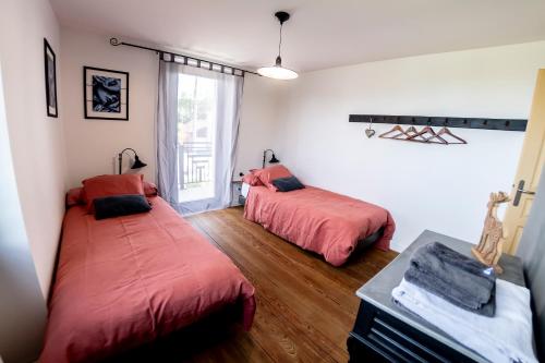 a bedroom with two beds and a window at Gite Amélie, Sauna, Spa au coeur des Vosges in Housseras
