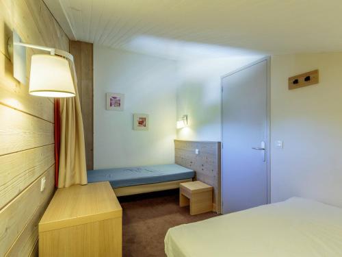 une petite chambre avec un lit et une armoire dans l'établissement Appartement lumineux avec balcon, Wi-Fi & piscine chauffée à Plagne 1800 - FR-1-351-173, à La Plagne Tarentaise