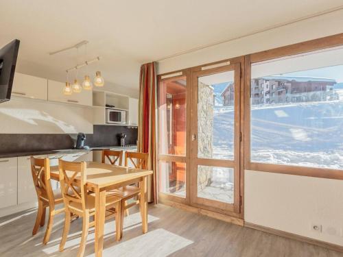une cuisine avec une table et des chaises et une fenêtre dans l'établissement Charmant appart. skis aux pieds, terrasse sud, central, 4 pers, TV, parking, casier à ski - FR-1-351-148, à La Plagne Tarentaise