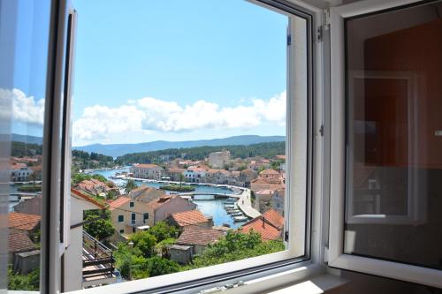 a window with a view of a river and buildings at Apartments Ena in Vrboska