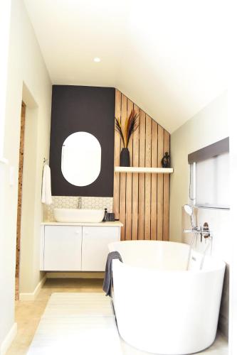 a bathroom with a white tub and a sink at Stella Maris #4 Self-catering in Swakopmund