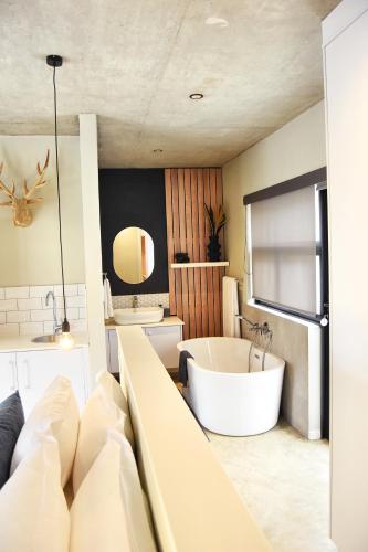 a bathroom with a large tub and a sink at Stella Maris #4 Self-catering in Swakopmund