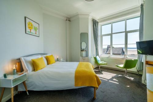 a bedroom with a bed and a large window at Corner Beech House in Grange Over Sands