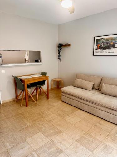 a living room with a couch and a table at 2p - vue mer et montagne - Monaco in Beausoleil