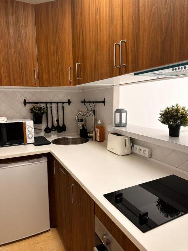 a kitchen with wooden cabinets and a white counter top at 2p - vue mer et montagne - Monaco in Beausoleil