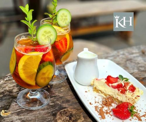 two glasses of fruit and a piece of cake on a table at Kings Head - Riverside, Ravenstonedale in Ravenstonedale