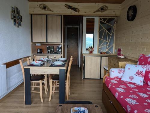 une cuisine et un salon avec une table et un canapé dans l'établissement Perce-neige, à Murat-le-Quaire