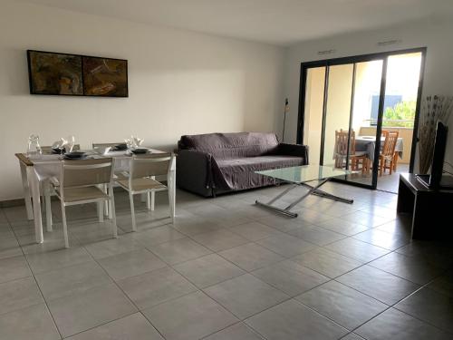 un salon avec un canapé et une table dans l'établissement T2 de standing à Porticcio, proche plage et commerces, à Grosseto-Prugna