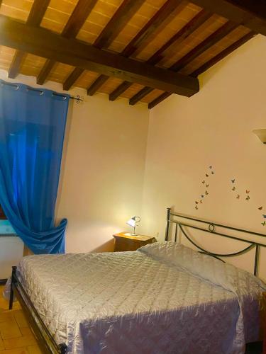 a bedroom with a bed and a blue curtain at Le Ghiande in Spello