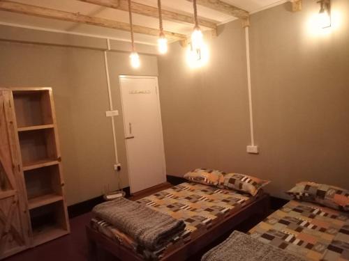 シロンにあるLarry's Ville BnBの照明付きの部屋にベッド2台が備わる部屋
