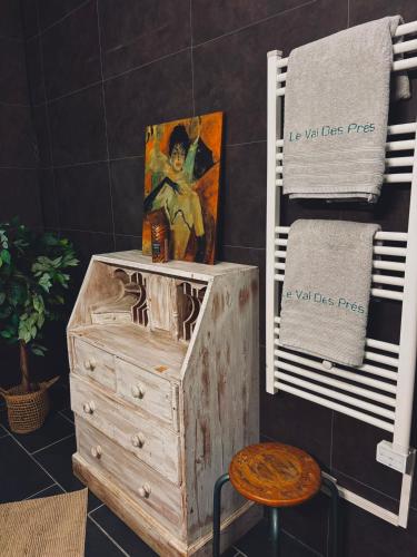 a bathroom with a wooden dresser and a painting on a wall at "Le Val des Prés" Atypique, Chambres spacieuses dans ancienne usine in Beauficel-en-Lyons