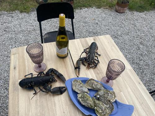 a table with two lobsters and a bottle of wine at Esquinandra - Chambre randonneurs et cyclistes - GR 223 - Quai des Ormes in Barneville-Carteret