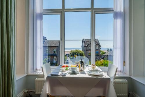 a table in a room with a large window at Corner Beech House in Grange Over Sands