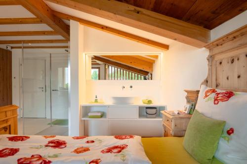 a bathroom with a sink and a bed in a room at zuLAVOGL in Kastelruth