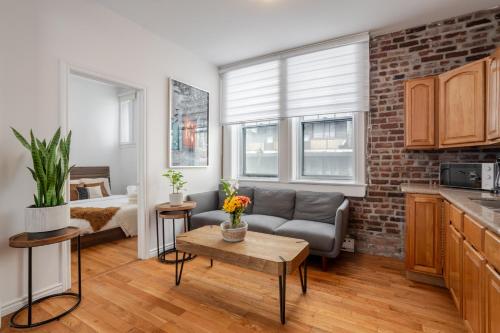 a living room with a couch and a bed in a room at Premium Location Stylish 3BR downtown Montreal in Montréal