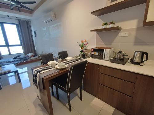 a kitchen with a table with chairs and a microwave at Bali Melaka SeaView WaterPark 2-5Pax 5minJonker Projector in Melaka
