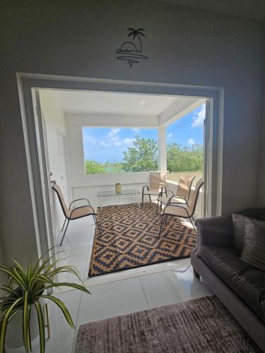 a living room with a couch and a table and chairs at The Harvest of Love 4 Modern, Prime Location in Lance aux Épines