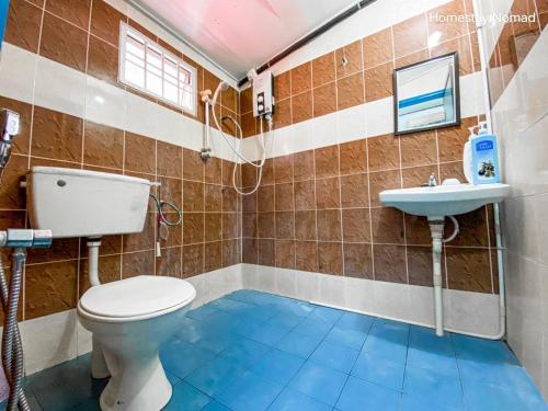 un baño con inodoro y lavabo en Homestay Nomad Kuala Terengganu, en Kuala Terengganu