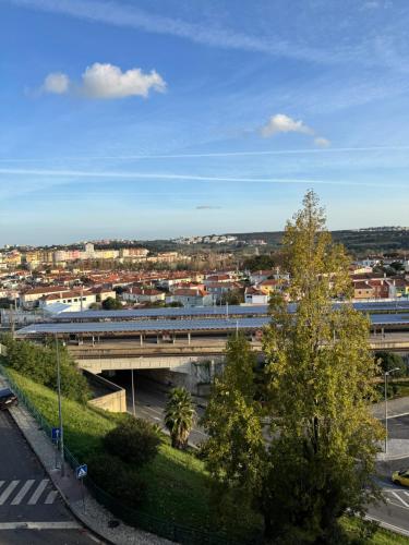 a train traveling over a bridge over a city at Modern 2BR Apartment with City Views I Near Lisbon by LivinInLisboa in Queluz