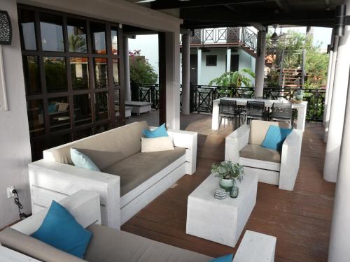 a patio with couches and a table on a porch at Blue Bay Villa Bon Bini. in Willemstad