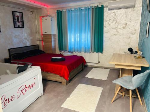 a bedroom with a red bed and a table and a chair at Love Room in Baia Mare
