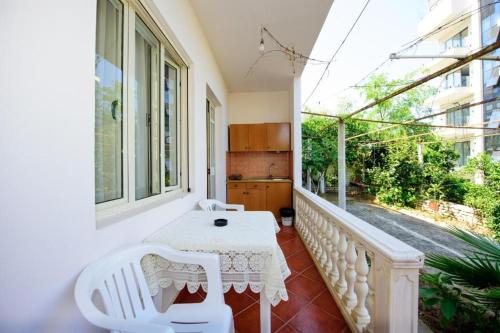 a white table and chairs on a balcony at Rei’s place in Vlorë