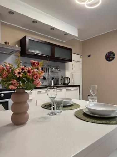 a kitchen with a table with glasses and a vase with flowers at Daisy in Lokev
