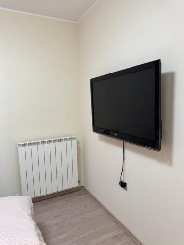 a flat screen tv hanging on a white wall at Daisy in Lokev