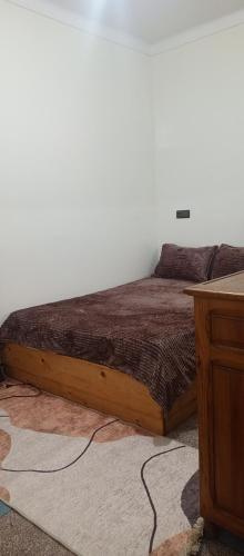 a bed with a wooden frame in a room at Rachid Local in Agadir
