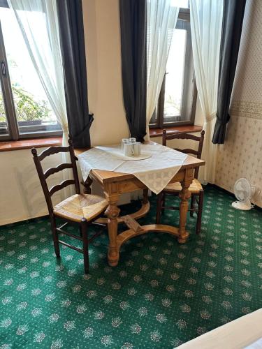 a table and two chairs and a table and a table and window at ART hotel MAXIM in Frýdek-Místek
