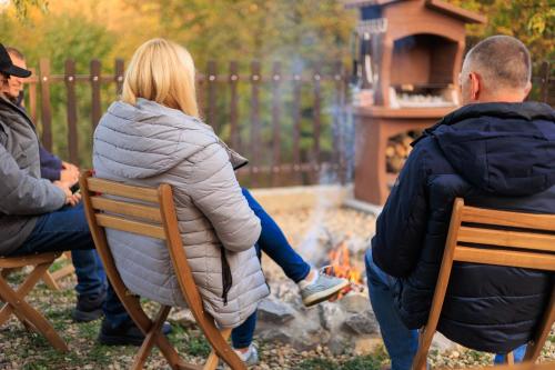 a woman sitting on a chair in front of a fire at Villa LipaHills in Ripanj