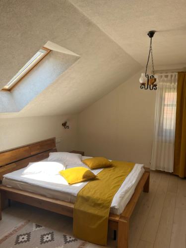 a bedroom with a large bed with yellow pillows at Cozy Apartment in Braşov