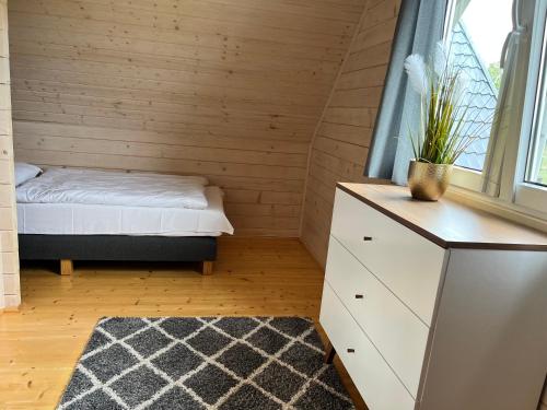 a small bedroom with a bed and a window at Domki Liza in Dziwnów