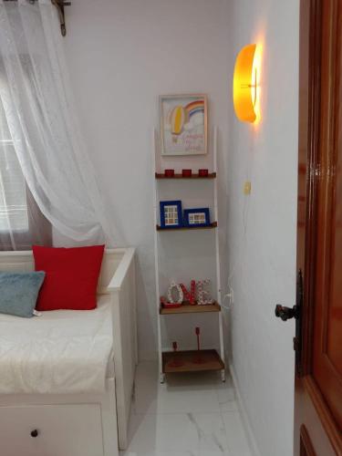 a small bedroom with a bed with a red pillow at Top appartement in Cabo Negro