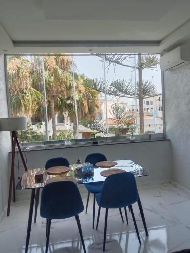 a table and chairs in a room with a large window at Top appartement in Cabo Negro