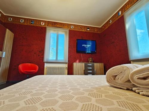 a bedroom with red walls and a bed with a television at Villa WOLF - A 1919 original Swiss Villa with Garden near Como in Balerna