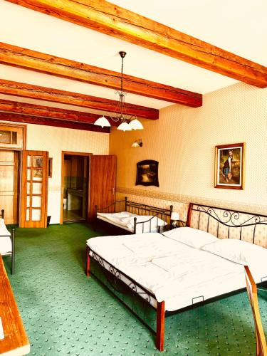 a bedroom with two beds and a green floor at ART hotel MAXIM in Frýdek-Místek