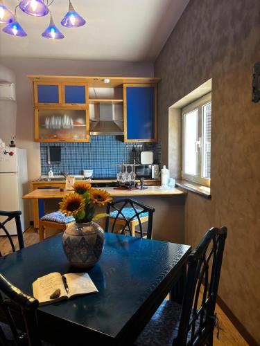 a kitchen with a table with a vase of flowers on it at La Casetta di Mary sulla Via dei Tusci in Castiglione in Teverina