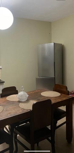 a dining room table with chairs and a refrigerator at Kipoossa in Mesochórion