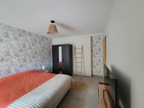 a bedroom with a bed and a wall at Sous le clocher 