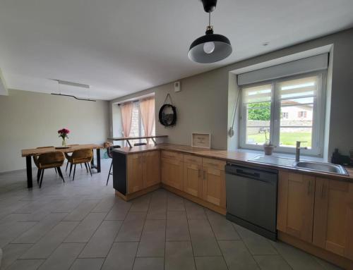 a kitchen with wooden cabinets and a table and a window at Sous le clocher 