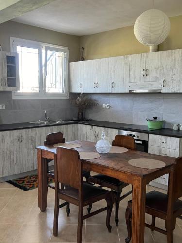 a kitchen with a wooden table and chairs at Kipoossa in Mesochórion