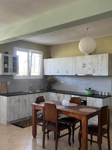 a kitchen with a wooden table with chairs and a tableasteryasteryasteryasteryastery at Kipoossa in Mesochórion