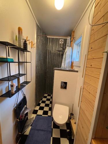 a bathroom with a toilet and a black and white checkered floor at Hus Siknäs in Mora