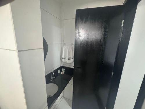 a bathroom with a toilet and a black door at BSH FLATS - Melhor custo benefício in Campina Grande